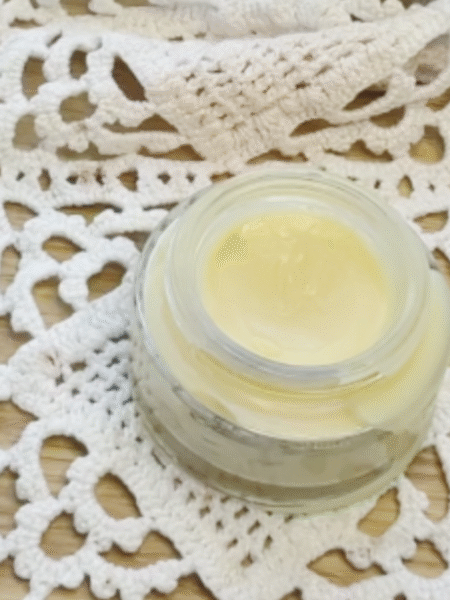 se muestra un tarro de cristal pequeño sin tapa que contiene el bálsamo labial