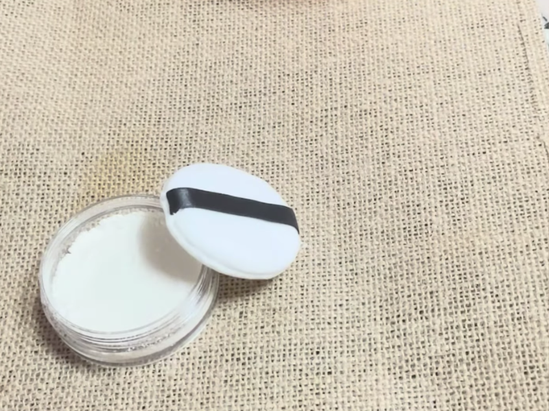 polvera con borla con los polvos perfumados corporales